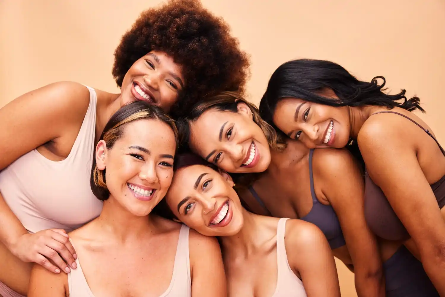 Smiling women of diverse skin tones showcasing healthy, radiant skin, representing regenerative skincare and natural skin renewal